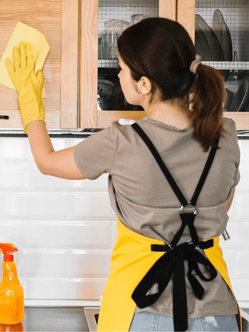 woman cleaning kitchen cabinet